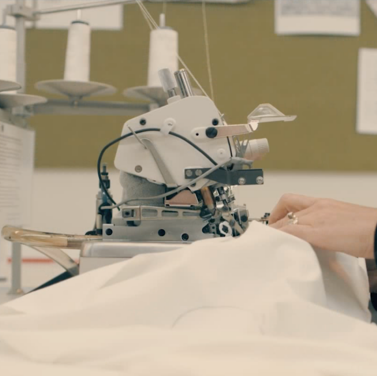 Organic cotton jersey passing under the needle of an industrial sewing machine.